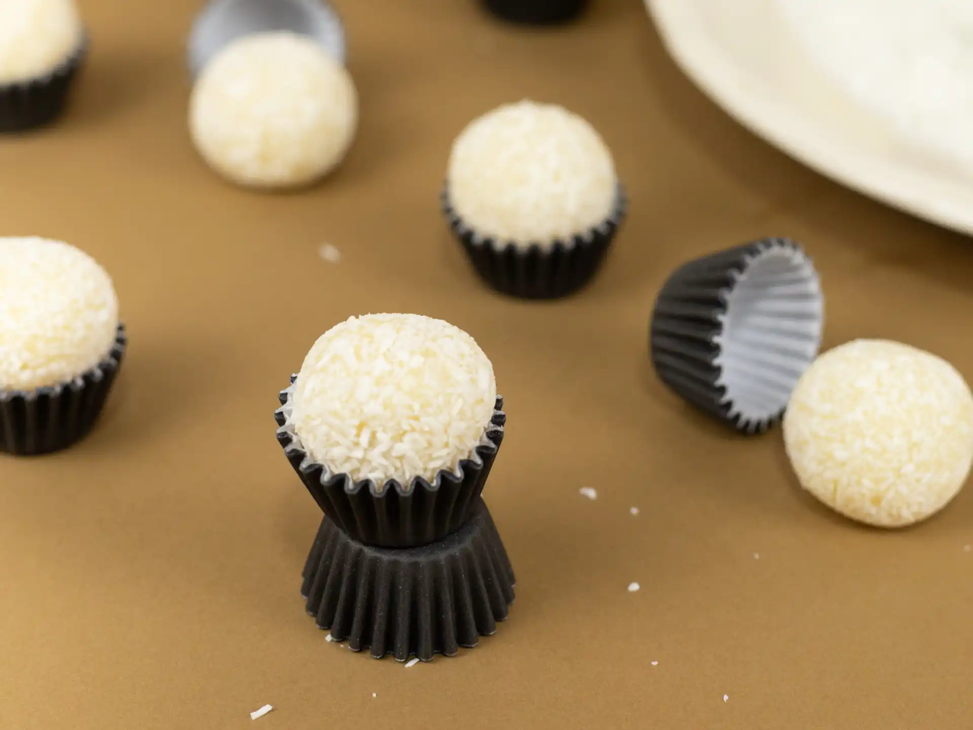 Beijinho tradicional feito com leite condensado, coco, creme de leite e leite de coco, enrolado no coco ralado.