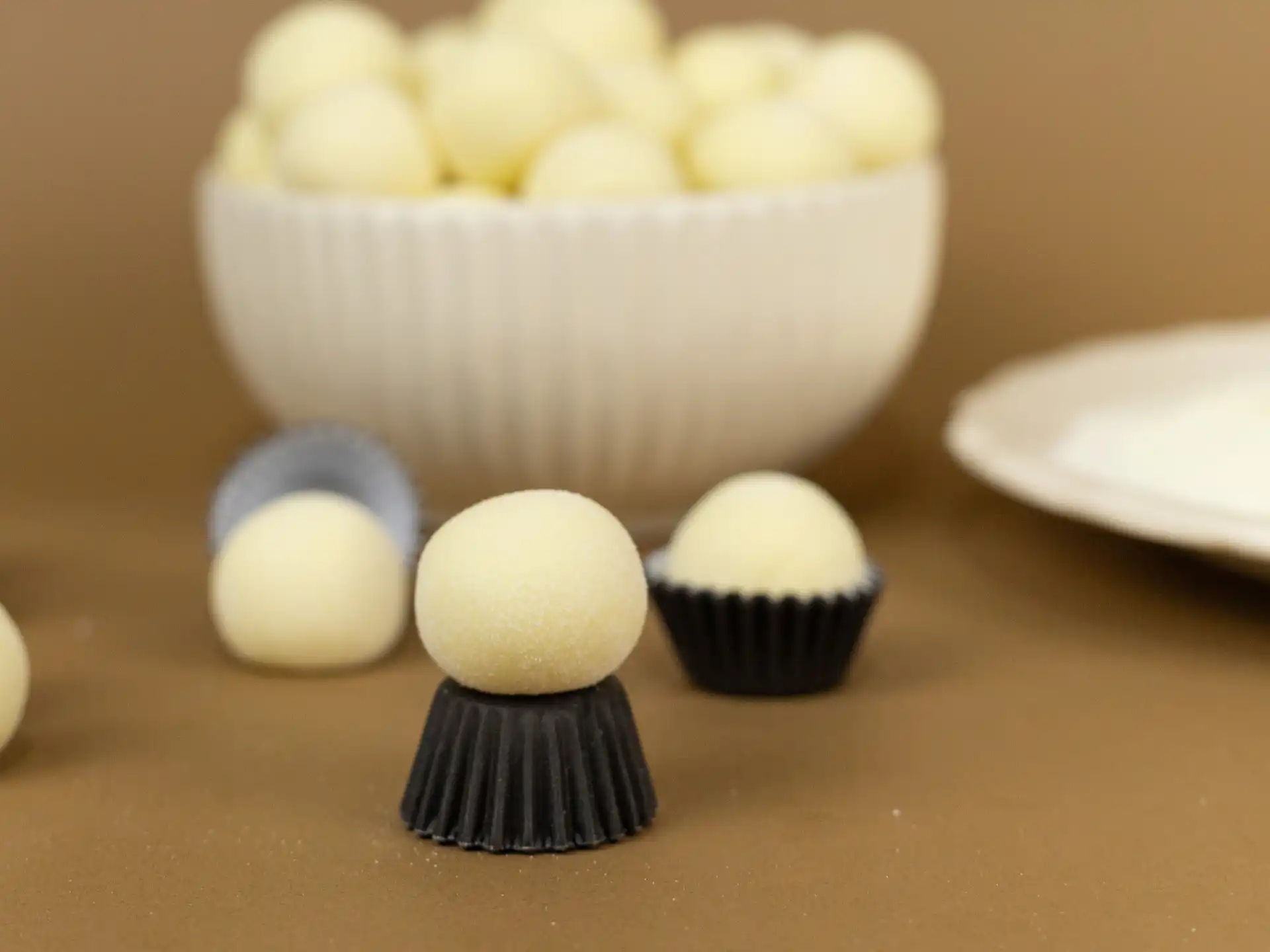 Doce de leite Ninho com massa crua, feito com leite em pó integral, açúcar e leite de coco, enrolado em leite em pó.