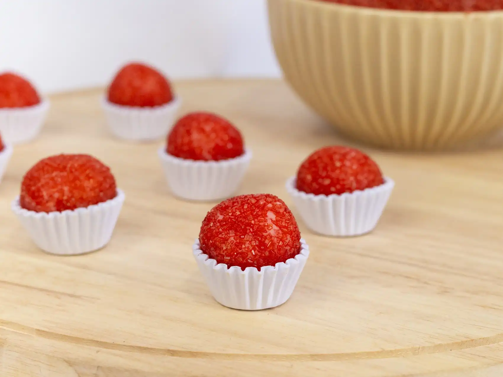 Doce artesanal sabor morango, feito com leite condensado, coco, creme de leite e pó de morango, enrolado em açúcar vermelho.