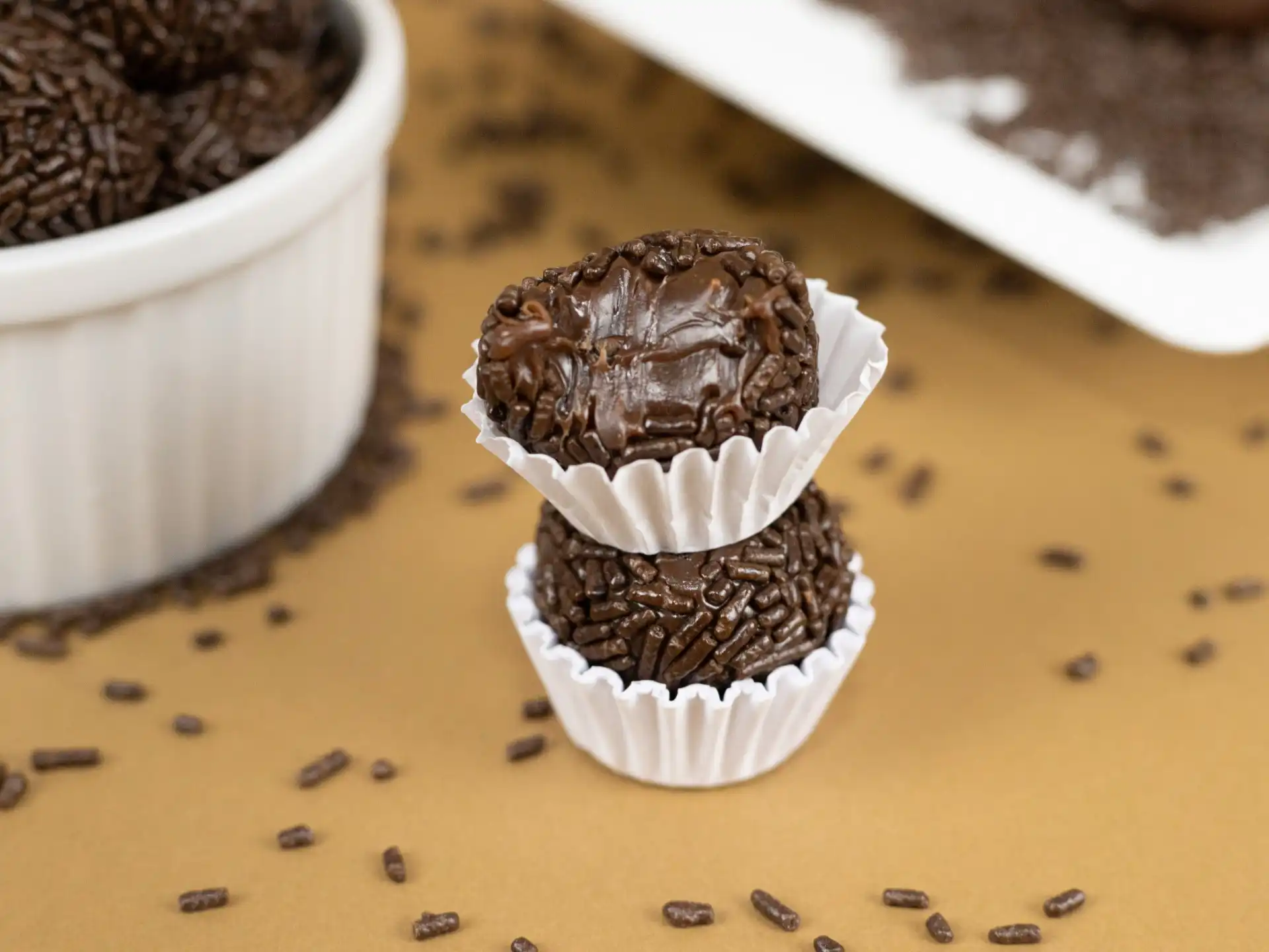 Brigadeiro tradicional, coberto com granulado, em uma forminha decorativa, ideal para festas e eventos.