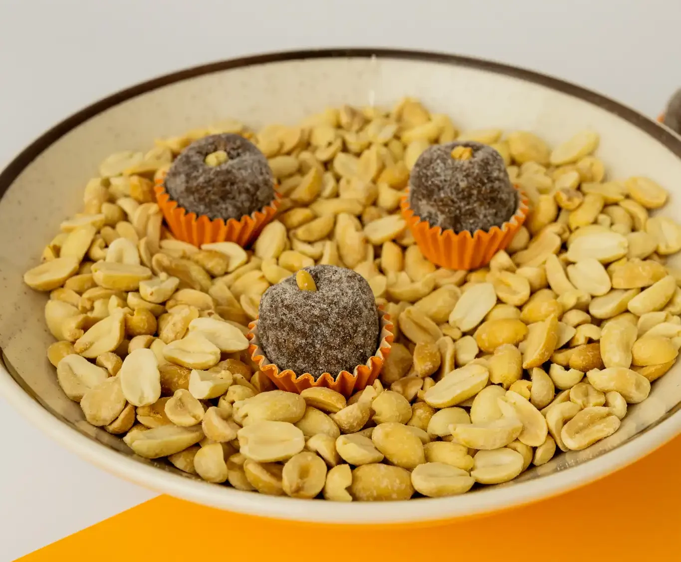 Cajuzinho, feito com amendoim torrado, cacau, açúcar e leite de coco, finalizado com um grão de amendoim.